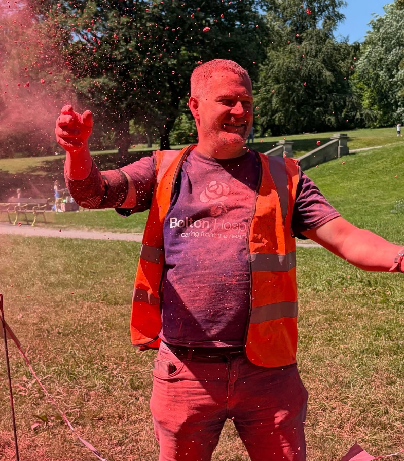 Bolton Hospice colour run volunteer throwing colour