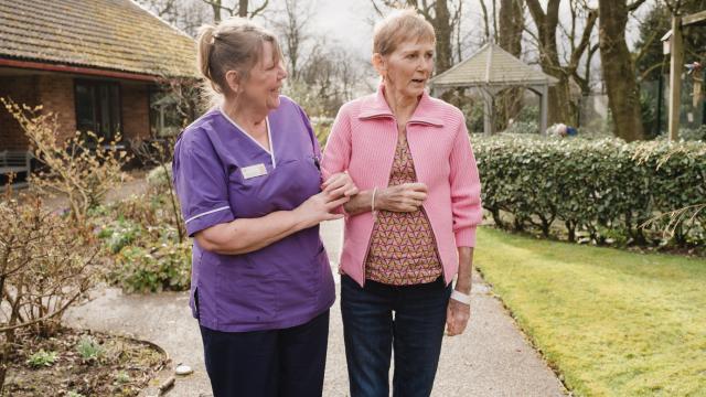 nurse and patient walking in garden